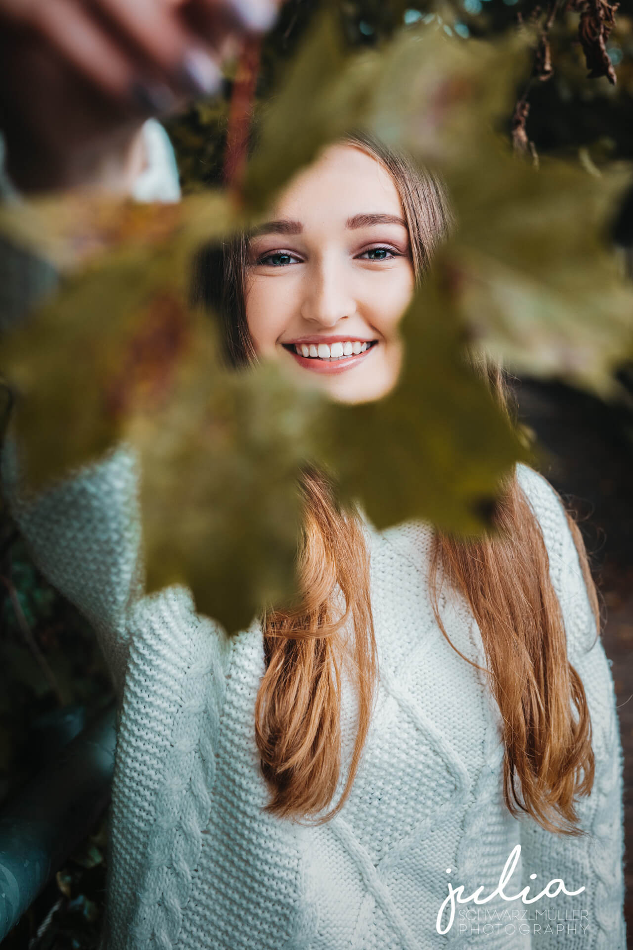 Portraitfoto im Herbst mit zerissenem Blatt